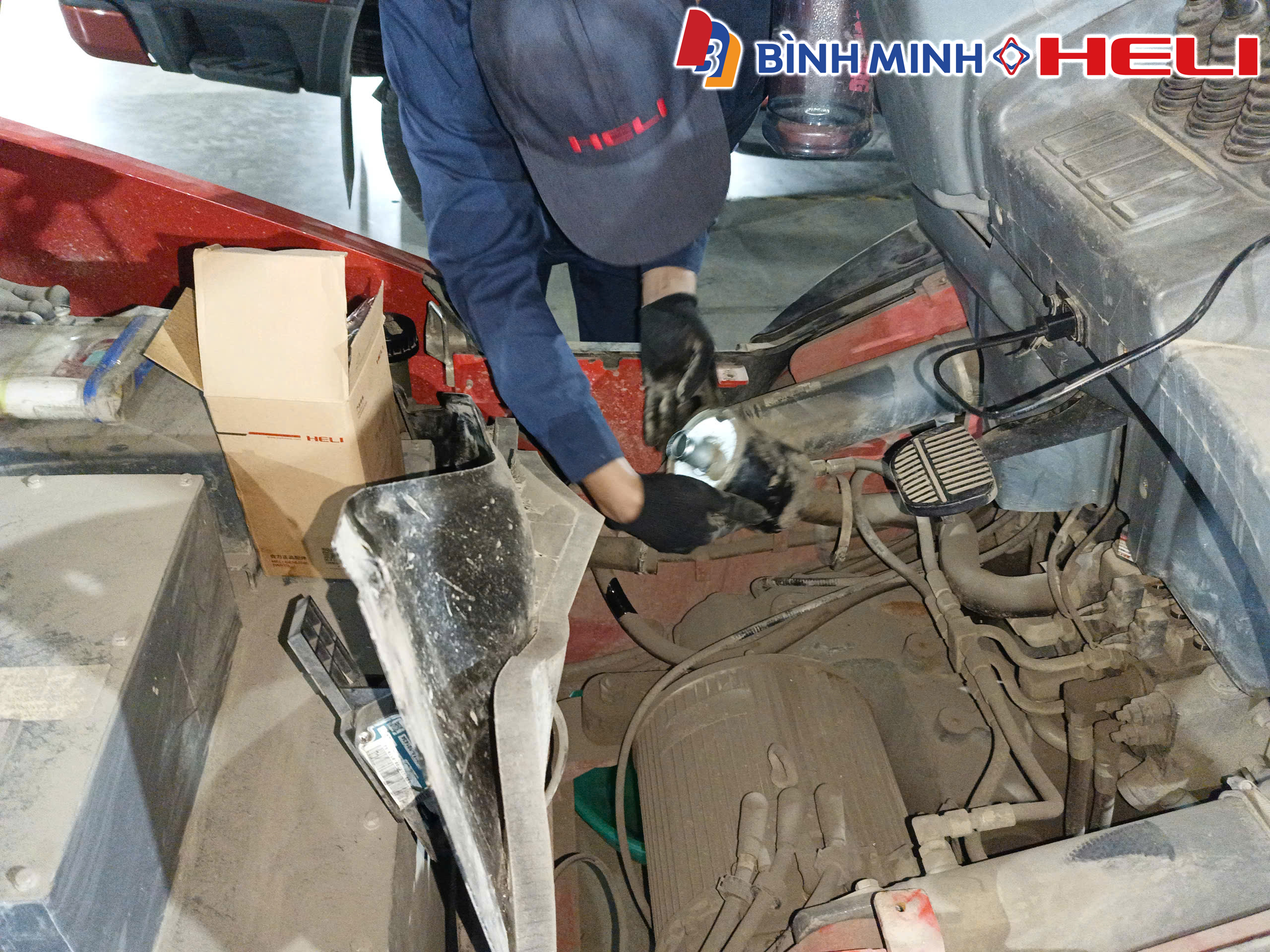 Vệ sinh và kiểm tra khoang động cơ xe nâng.